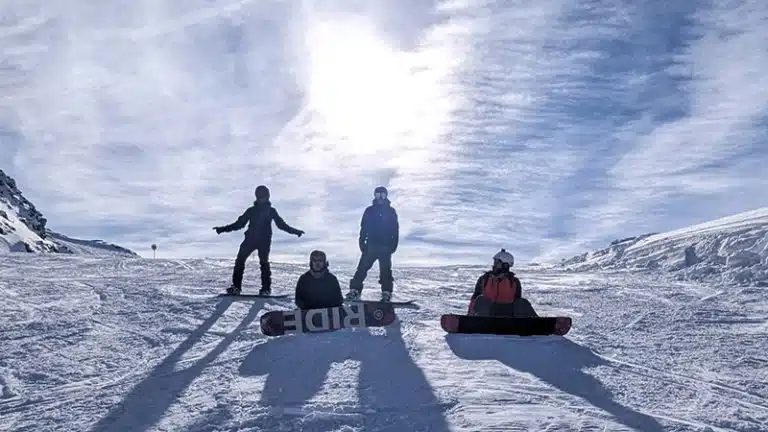 Groupe de snowboardeurs adultes en haut d’une piste dans les 3 Vallées lors d’un stage aux Menuires