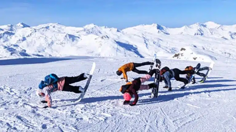 stage de snowboard aux Menuires avec élèves réalisant une figure